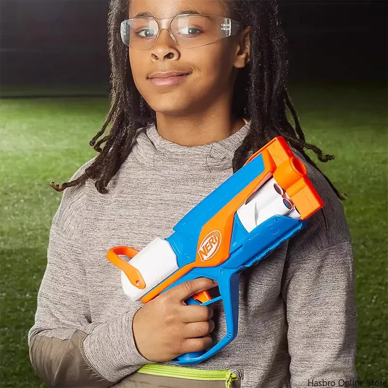 Girl holding blue and orange nerf gun in front of her